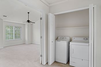 A room with a ceiling fan and two washing machines.